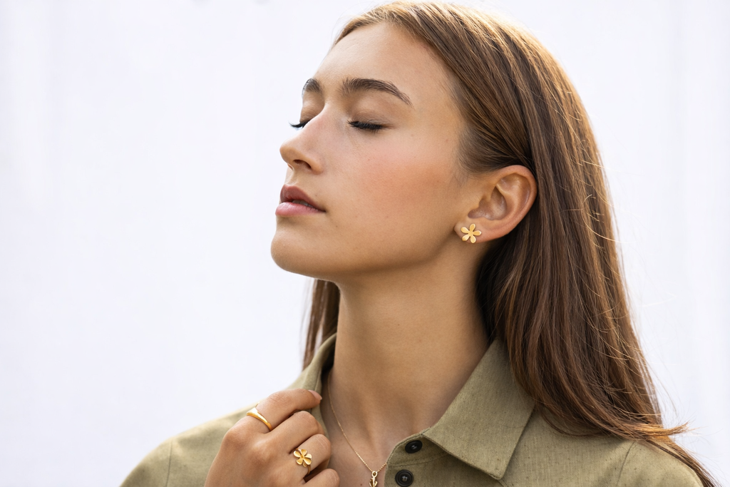 Minimalist gold flower stud earrings close-up, Scandinavian inspired jewelry for women