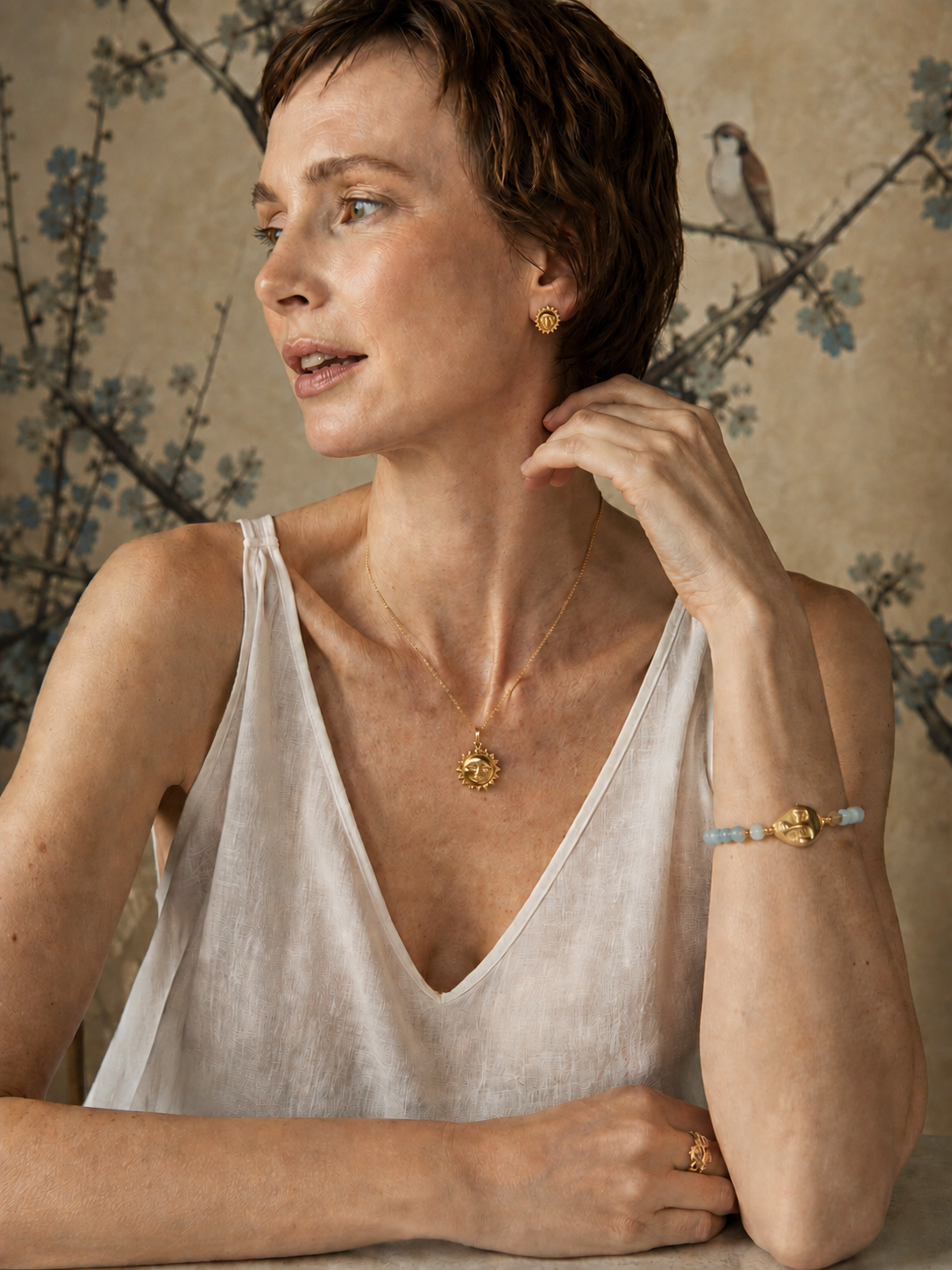 Woman wearing Nordic Editorial Set featuring Scandinavian gold necklace, minimalist stud earrings, and aquamarine bracelet in soft editorial Nordic style